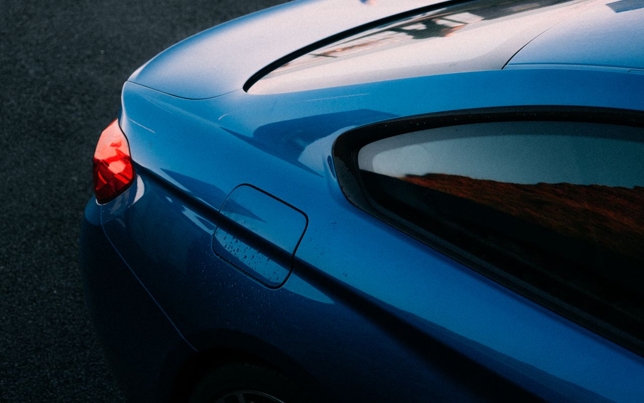 Elegant blue car close-up showcasing aerodynamic design and vibrant color.