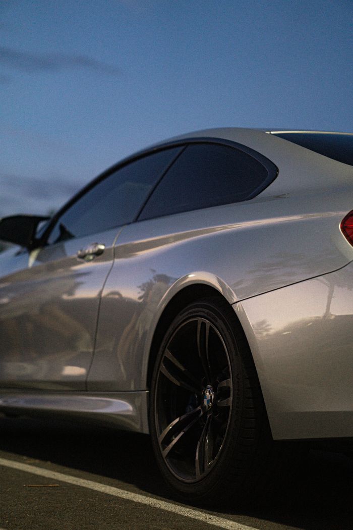 Close-up of a sleek silver car with reflective surfaces at twilight.