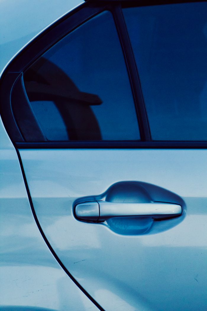 Close-up of a car door handle with blue tint. Modern automotive detail.